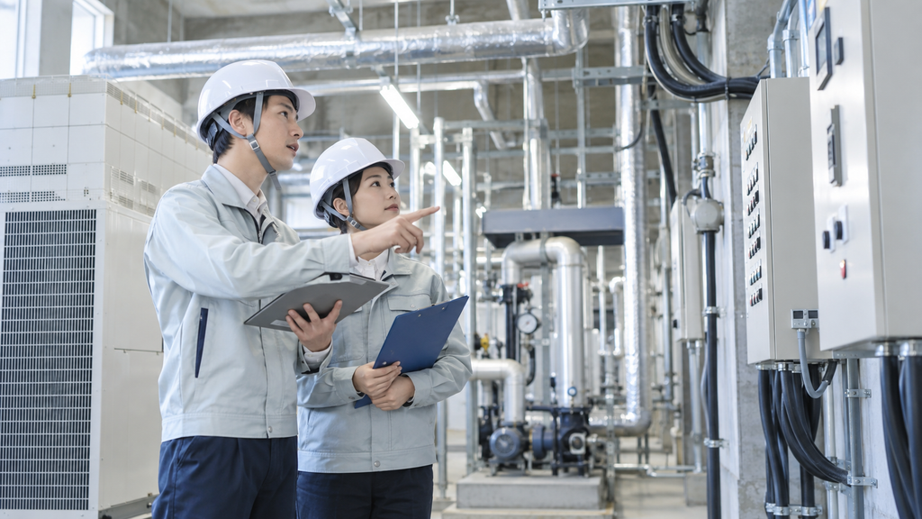 工場内の設備・配管・電気設備を点検する作業員のイメージ